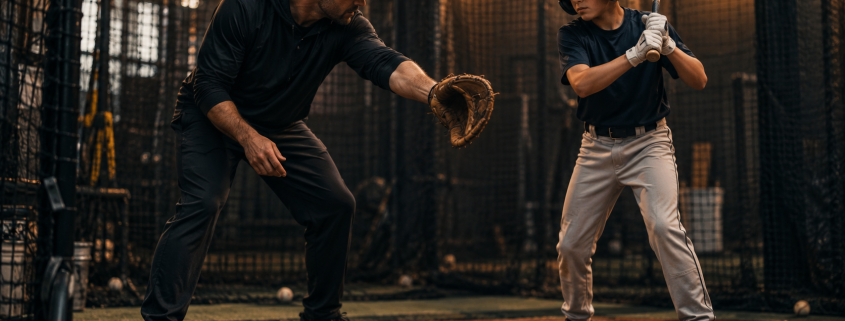 Baseball coach demonstrating the Barry Bonds drill with youth hitter in batting cage
