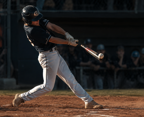 Baseball hitter showing body dipping in swing at contact with collapsing backside and bent spine