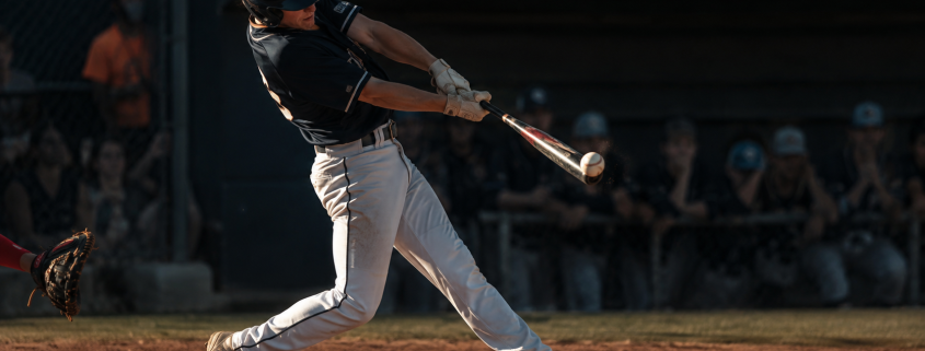 Baseball hitter showing body dipping in swing at contact with collapsing backside and bent spine