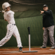 Youth baseball player at the tee with coach — baseball hitting lessons for swing mechanics