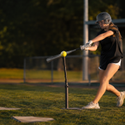 Softball player hitting off a tee with overload bat — softball hitting drills for swing mechanics