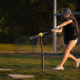 Softball player hitting off a tee with overload bat — softball hitting drills for swing mechanics